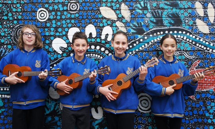 Four students playing Ukelele