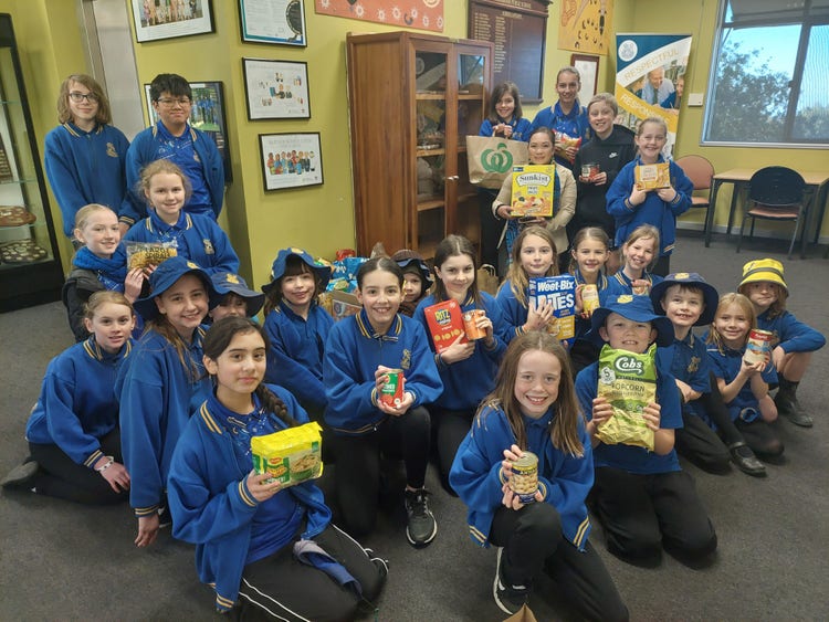 A group of students holding food donations for charity