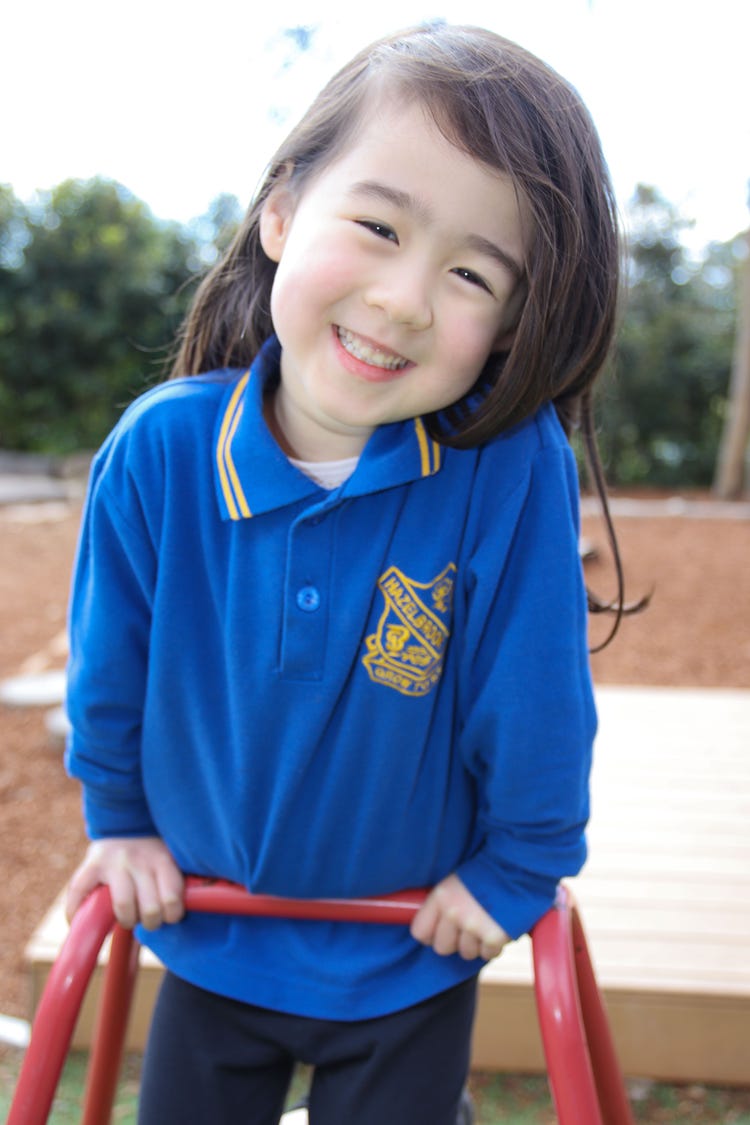 Close up of young female student smiling to camera while on climbing equipement